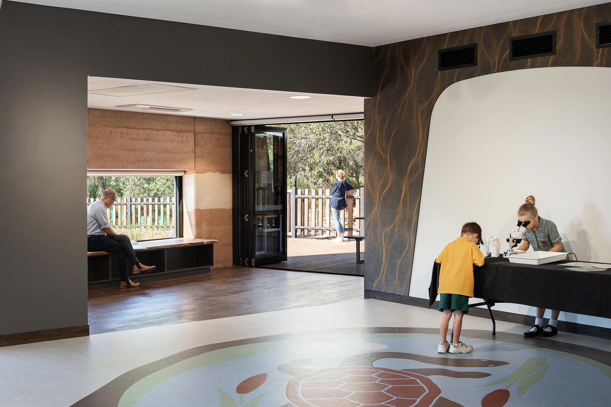 Interior learning space with wetland ecosystem floor graphic and cork feature wall