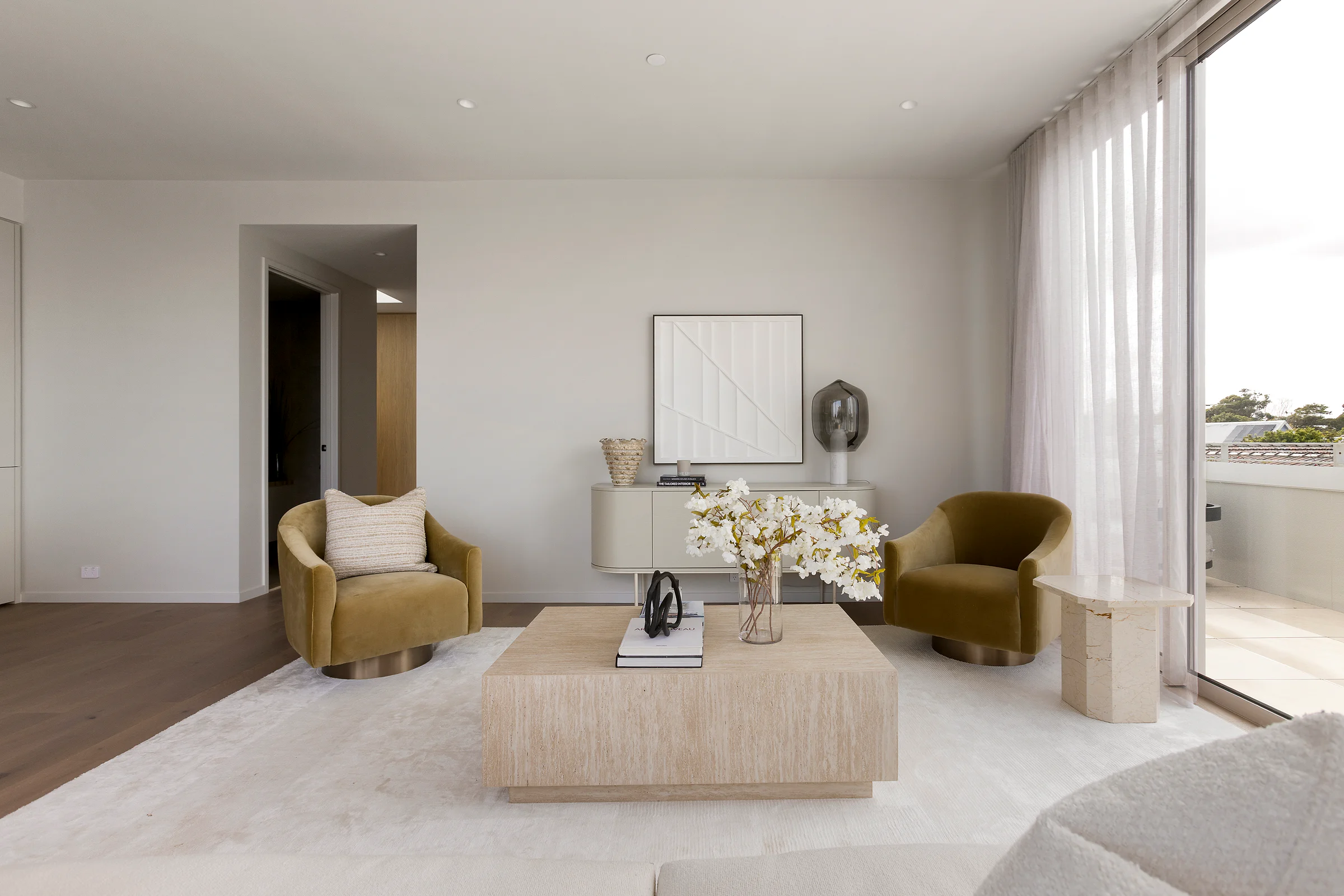 Sandringham Residences - Living room with mustard armchairs, marble coffee table and cream console