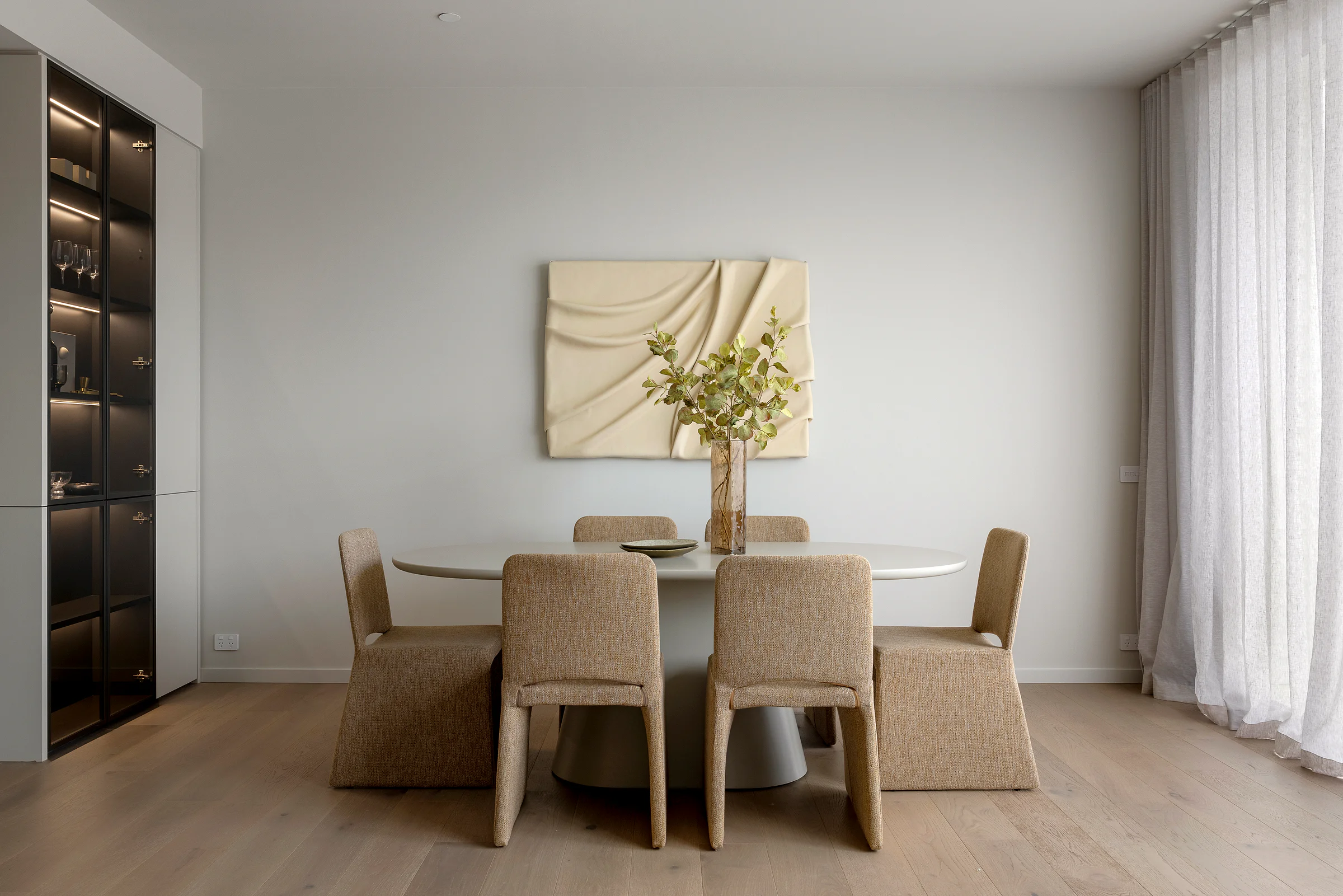 Sandringham Residences - Dining room with round pedestal table and black display cabinet