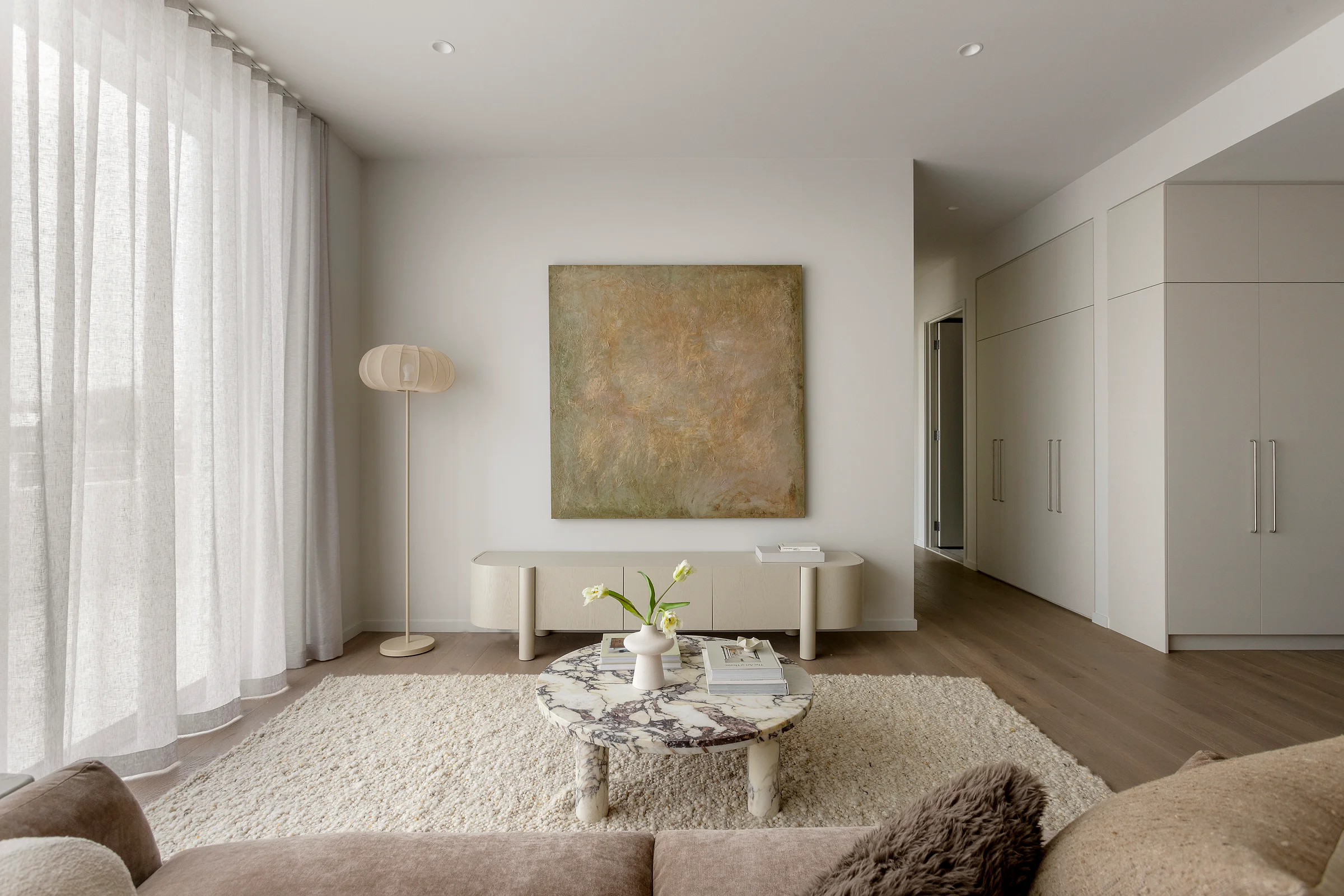 Sandringham Residences - Living area with marble coffee table, abstract art and full-height glazing