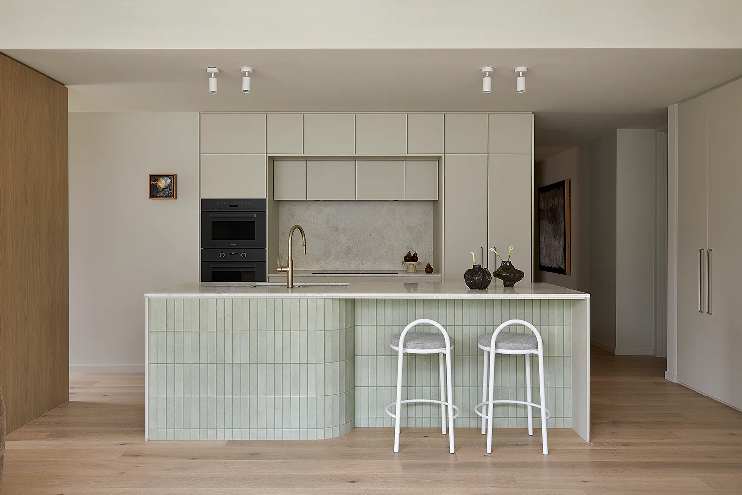 Sandringham Residences - Open-plan kitchen with sage-green ribbed island and marble countertop