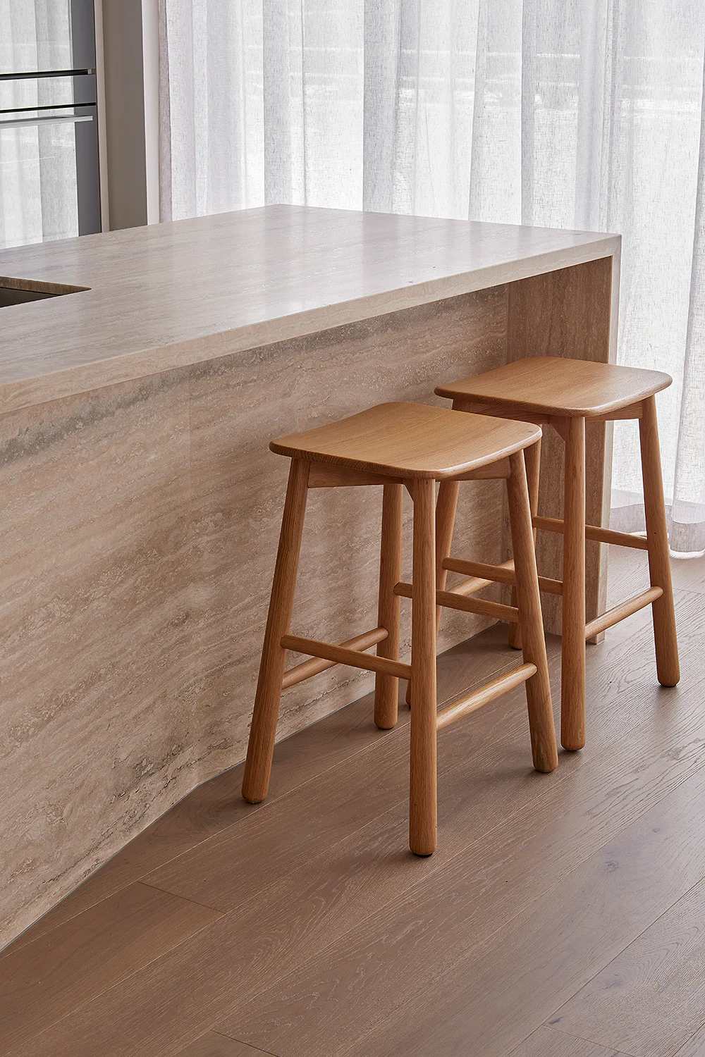 Sandringham Residences - Kitchen counter detail with timber bar stools and sheer curtains